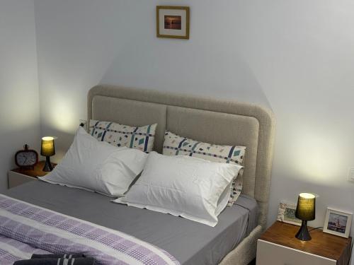 ein Schlafzimmer mit einem Bett mit weißen Kissen in der Unterkunft Design, space and light in La Marsa in Dar Tahar Zaouch