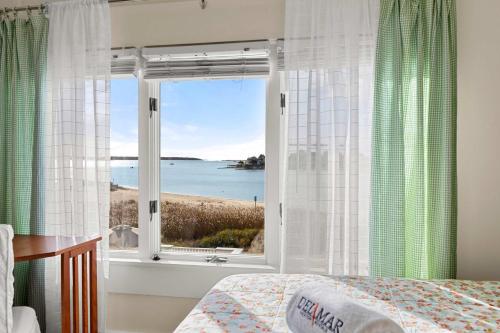 een slaapkamer met een raam met uitzicht op de oceaan bij Waterfront Private Beach Gorgeous Views in Hyannis