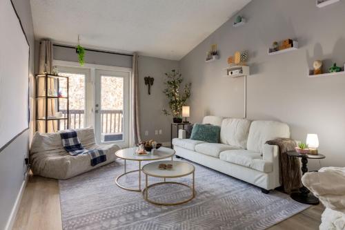 a living room with a white couch and a table at Casablanca - 3 BR Family & Game Haven in Calgary