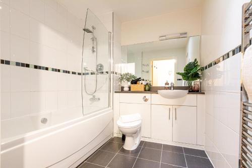 a bathroom with a shower toilet and a sink at The Viva Apartments Luxe in Birmingham