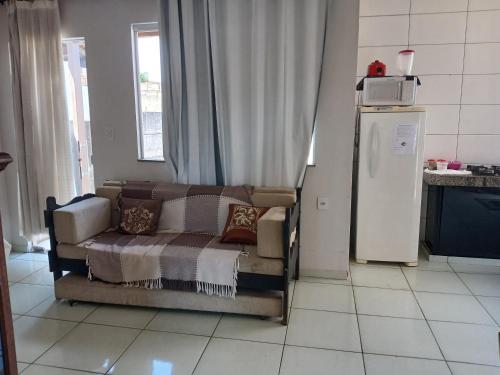 ein Wohnzimmer mit Couch und Kühlschrank in der Unterkunft Casa aconchegante in Pará de Minas