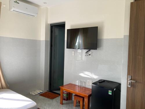 a room with a small table and a television on the wall at Hoàng Anh Hotel in Ấp Bàu Sen