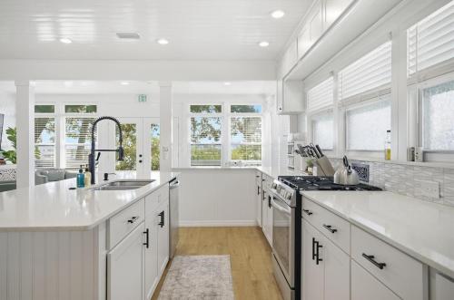a white kitchen with a sink and a stove at Waterfront Retreat Events Dock in St. Augustine