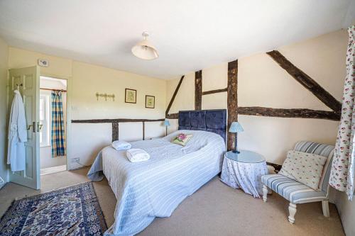 Cleaver Cottage في أندوفر: غرفة نوم بها سرير وكرسي