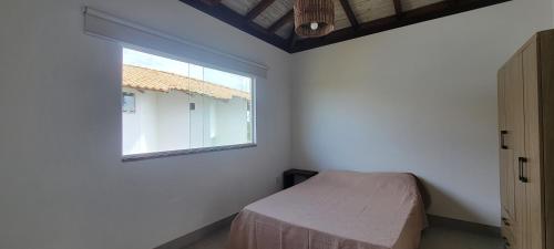 a bedroom with a small bed and a window at Casa Jardim in Marau
