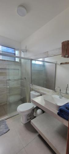 a bathroom with a toilet and a sink and a shower at Casa Jardim in Marau
