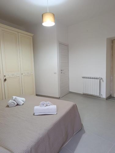 a white bedroom with two towels on a bed at B&B al Vicolo in Nicosia