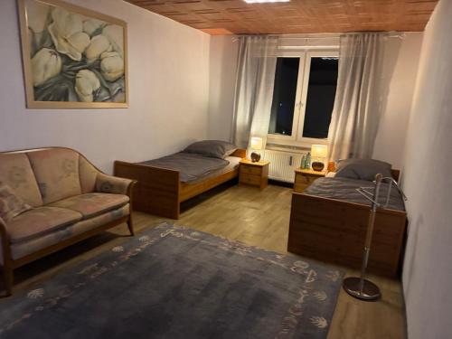 a room with two beds and a couch and a window at Dorfplatz in Klötze
