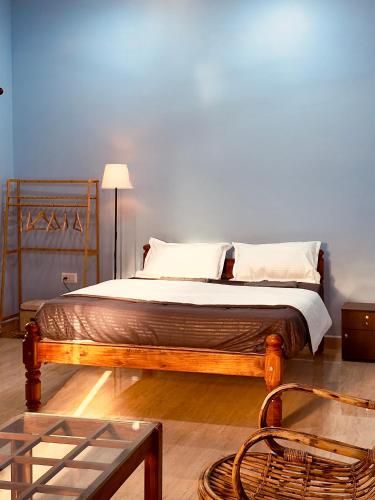 a bedroom with a bed with a wooden frame at Barefoot and Beyond - Crafted with Kenchas in Gokarna