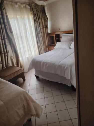 a hotel room with two beds and a window at Molata Rabs in Polokwane
