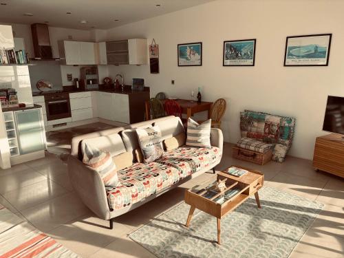 a living room with a couch and a table at Eight Water's Edge in Tenby