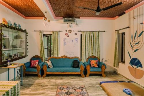 Una sala de estar con dos sillas y un sofá. en Kulture KonnectT Kurakanni, en Varkala