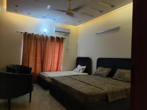 a bedroom with a bed and a couch and a window at Komal Residency in Islamabad