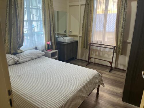 - une chambre avec un lit, un lavabo et une fenêtre dans l'établissement Max Garden and Pool, à Paramaribo