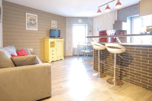 studio 2 personnes coeur de ville - proche plage في لي سابلِ دولونْ: غرفة معيشة مع أريكة وبار