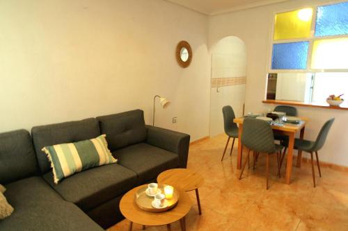 a living room with a couch and a table at Bungalow Brisa de Mar in Torrevieja