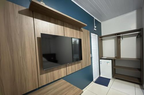 un soggiorno con una grande TV a schermo piatto a parete di Hotel Riviera a Aripuanã