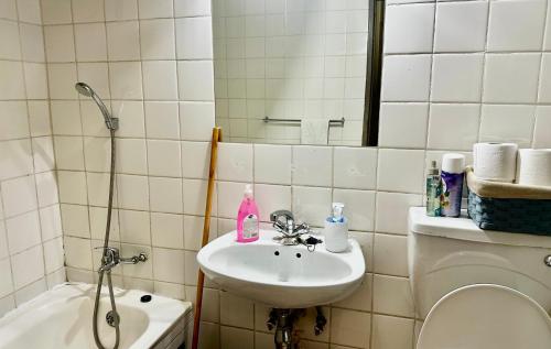 un bagno con lavandino, WC e specchio di Feel At Home Cosy Apartment a Gaborone