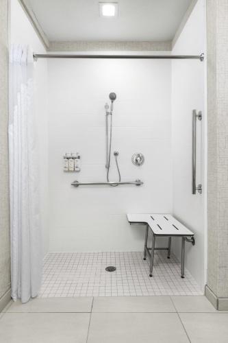 a white bathroom with a shower and a table at Holiday Inn Express Hotel & Suites Marina by IHG in Marina