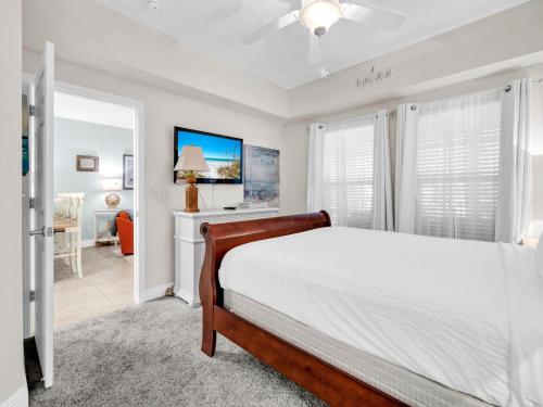 una camera da letto con un letto bianco e una scrivania di The Village 622 a Blue Gulf Beach