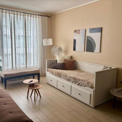 a bedroom with a bed and a table and a couch at Excelente departamento en Las Condes in Santiago