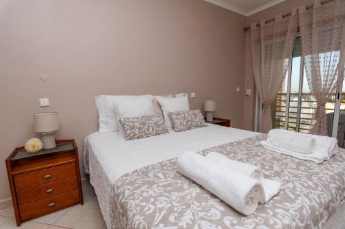 a bedroom with a white bed with towels on it at Ver o Mar in Albufeira