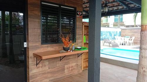 a room with a table next to a swimming pool at Cantinho das Palmeiras em Itapoá- Casa c piscina p 6 pessoas in Itapoa