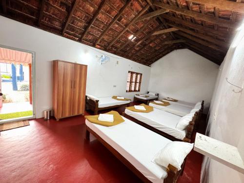 a room with three beds and a window at Rafters Retreat Coorg The Riverside Homestay in Srimangala