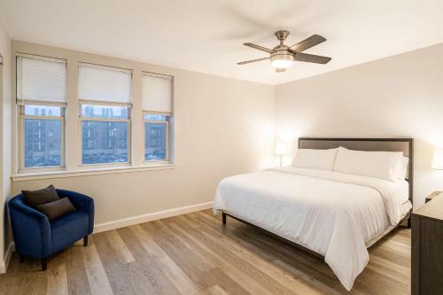 a bedroom with a bed and a blue chair at 2BR w King Bed Pool Steps to Forest Park CWE in Tower Grove