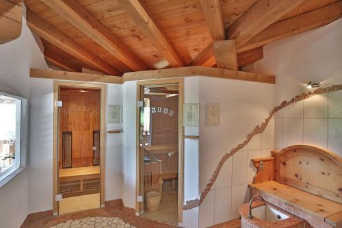 アルツル・イム・ピッツタールにあるKinderbauernhof Lenelerの木製の天井とガラスのドアが付いたバスルーム