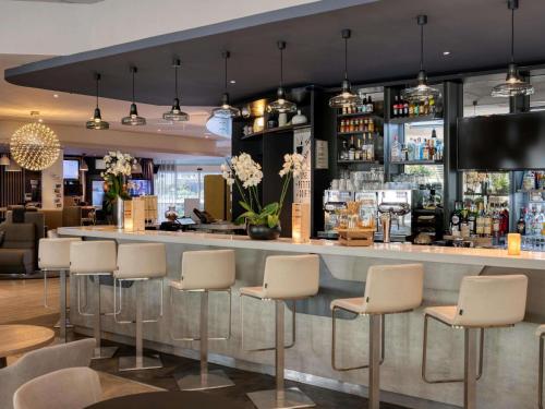 a bar in a restaurant with white stools at Novotel Paris Centre Bercy in Paris