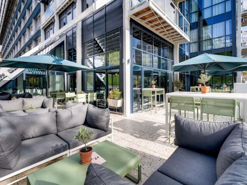 a patio with couches and umbrellas in front of a building at Novotel Paris Centre Bercy in Paris