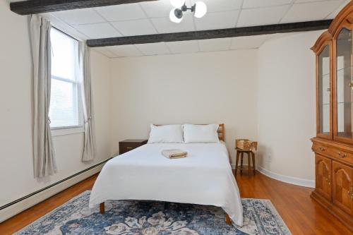a bedroom with a white bed and a window at All-American classic,18 min to Manhattan in Carlstadt