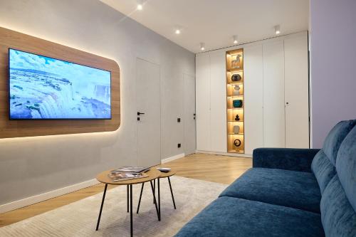 a living room with a blue couch and a table at CHANTTAL Luxury - ACADEMY in Bucharest