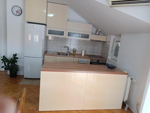 una cucina con mobili bianchi e un frigorifero bianco di Stan na dan Brčko a Brčko