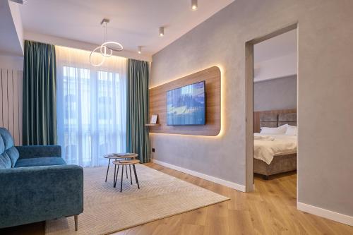 a hotel room with a bed and a blue couch at CHANTTAL Luxury - ACADEMY in Bucharest
