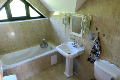 Un baño con lavabo y bañera y un lavabo. en Three Chalets Vrútky, en Vrútky