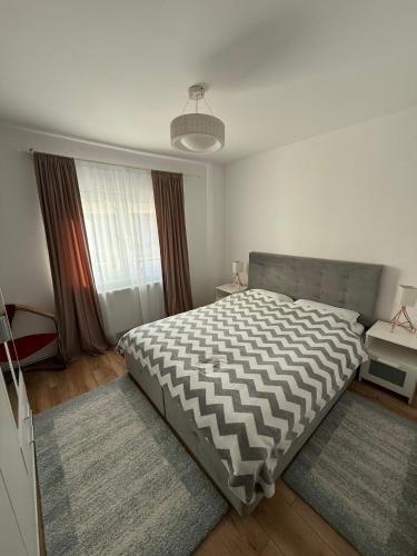 a bedroom with a large bed and a large window at Ingrino Apartament in Comăneşti