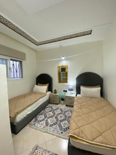 a bedroom with two beds and a rug at Dar El Yacout in Rabat