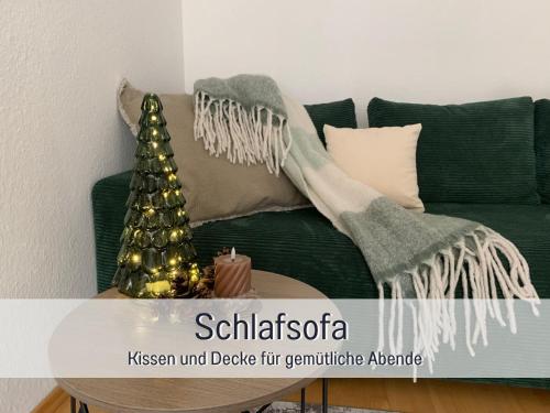 a green couch with a christmas tree on it at StayWest52 - Balkon, WLAN, Parkplatz in Ulm