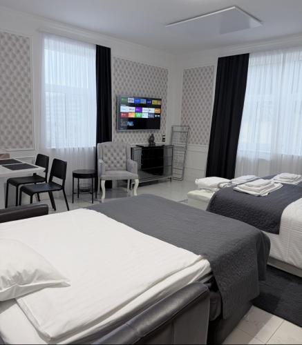 a hotel room with two beds and a television at SLOAPART Apartments in Rogaška Slatina