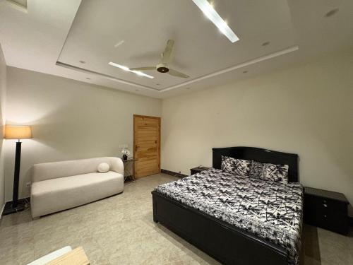 a bedroom with a bed and a couch in it at 1 - bedroom near Lyallpur galleria in Faisalabad