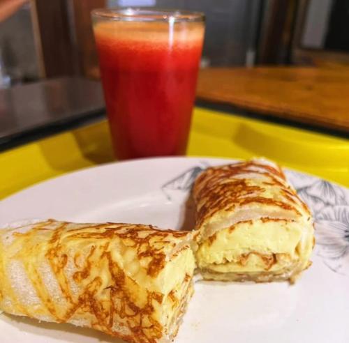 une assiette blanche avec deux pâtisseries et une boisson dans l'établissement Pousada Mar de vênus, à Fernando de Noronha