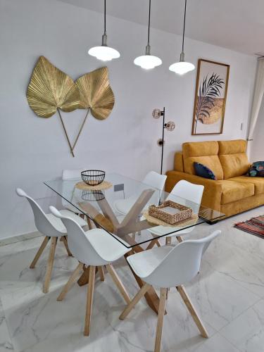 a dining room with a glass table and white chairs at Cocoonly in San Juan de los Terreros