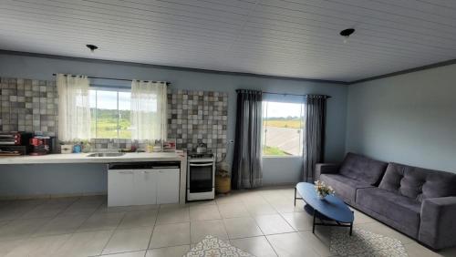 ein Wohnzimmer mit Sofa und eine Küche in der Unterkunft Yad elohai pousada israelense in Campo Alegre