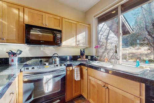 a kitchen with a stove and a sink and a window at Eagle Crest Village Lp Getaway in Redmond