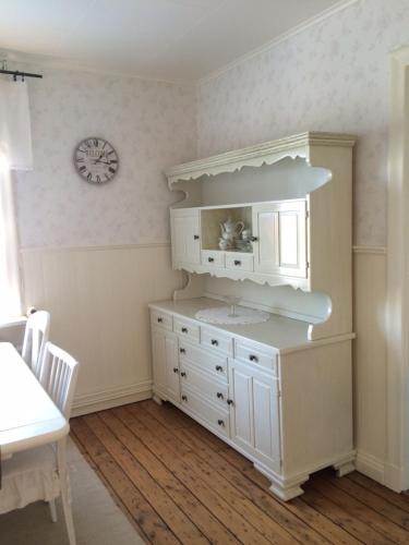 een badkamer met een wastafel en een klok aan de muur bij Gröna Lena in Sunne