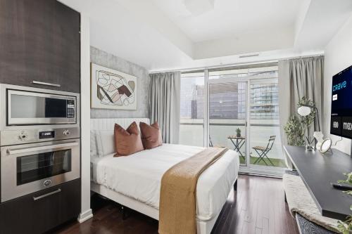 a bedroom with a bed and a large window at Stylish Downtown Studio with CN Tower Views in Toronto