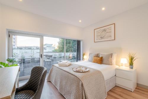 a bedroom with a bed and a large window at Bom Sucesso Executive Suites by HostWise in Porto