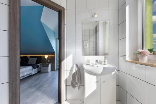 un bagno bianco con lavandino e specchio di Villa Bryza a Mechelinki